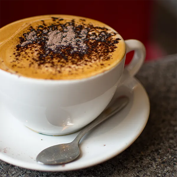 a cup of cappucino sits on a table